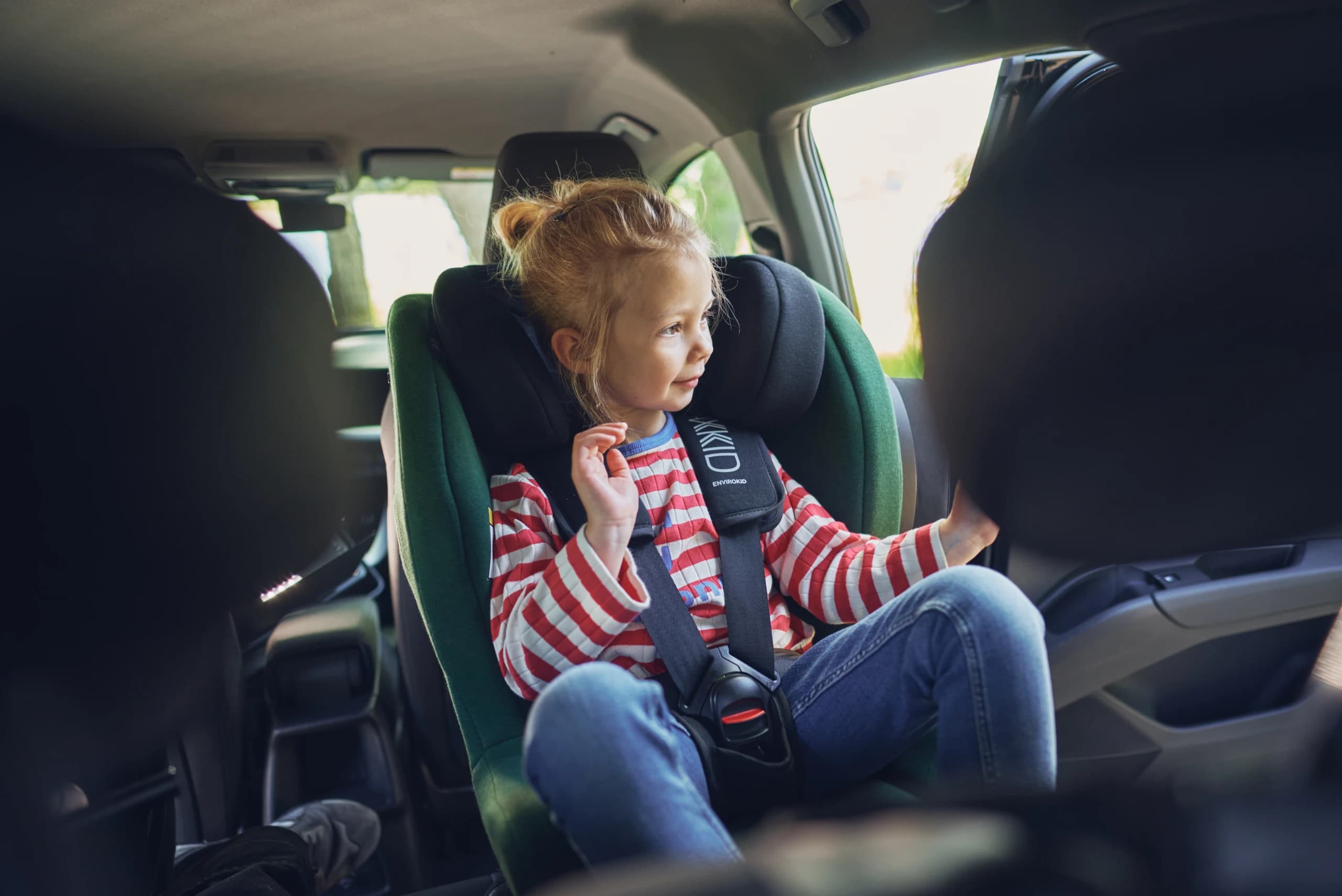 A child travelling rear-facing in an Axkid car seat