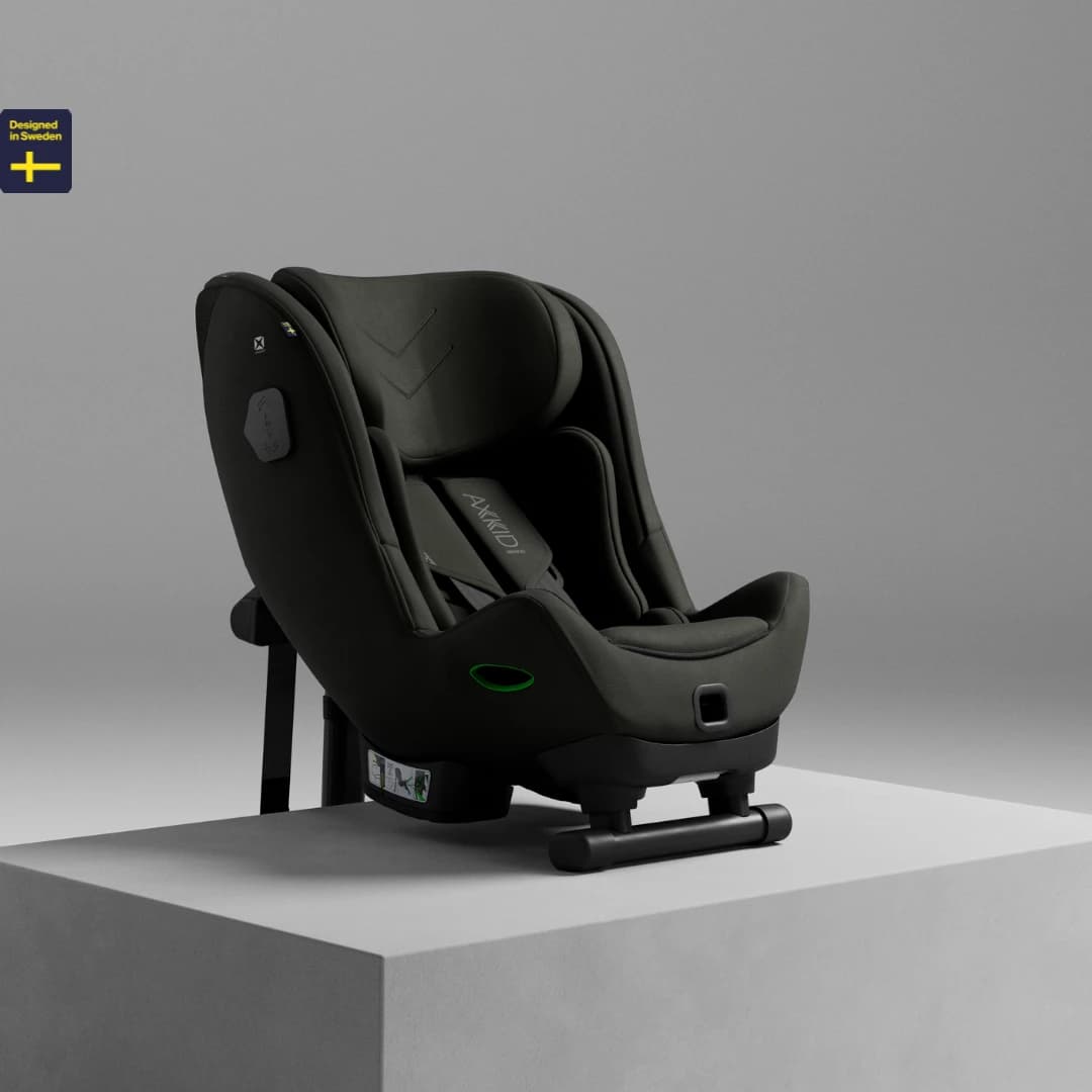 Axkid Minikid rear-facing child car seat on a studio plinth