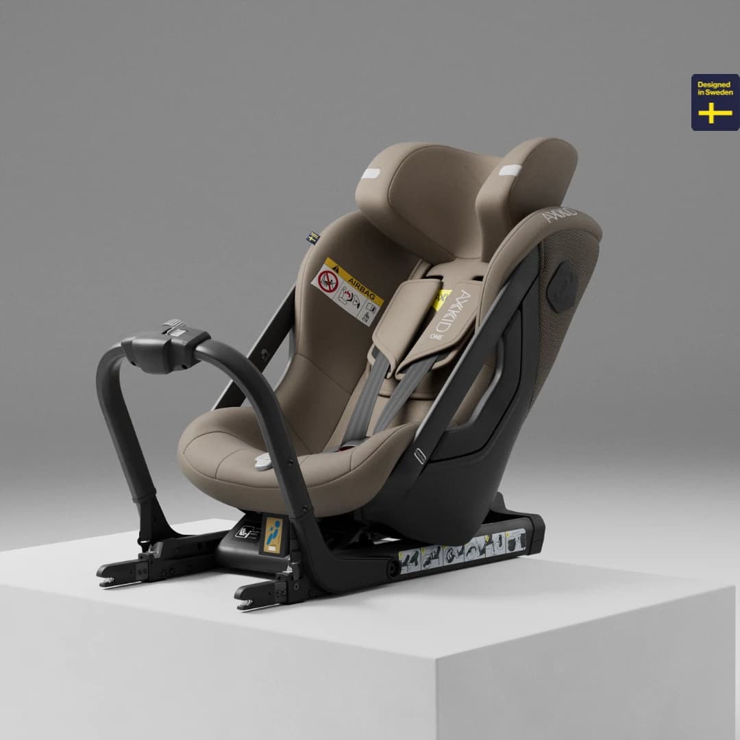 Axkid One rear-facing child car seat on a studio plinth
