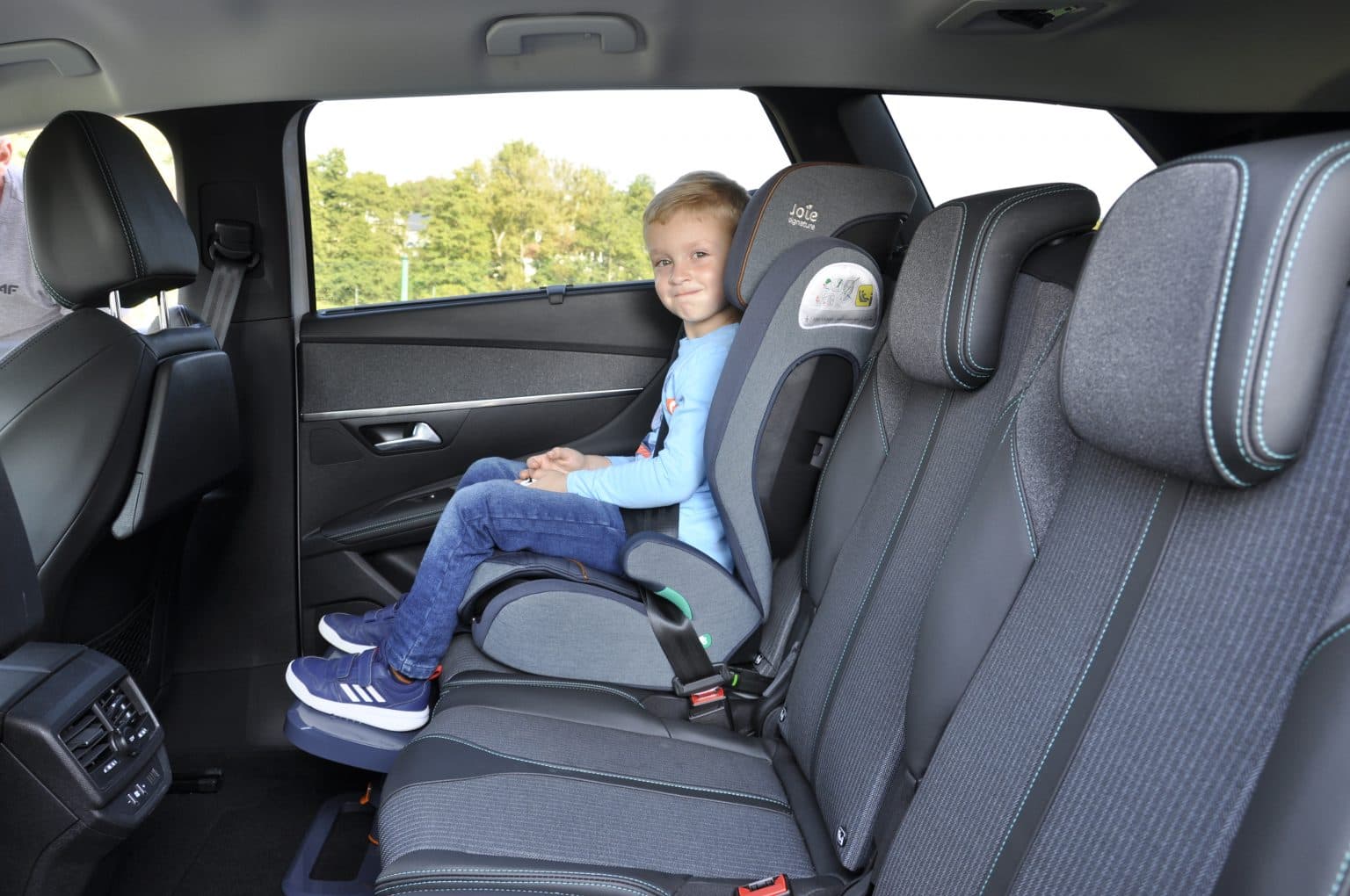KneeGuard Kids footrest installed beneath a booster seat