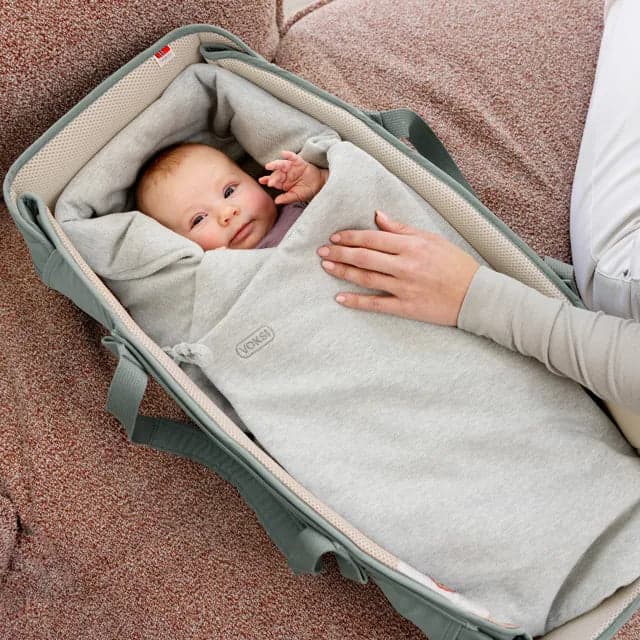 Baby wrapped in a green Voksi wool layer
