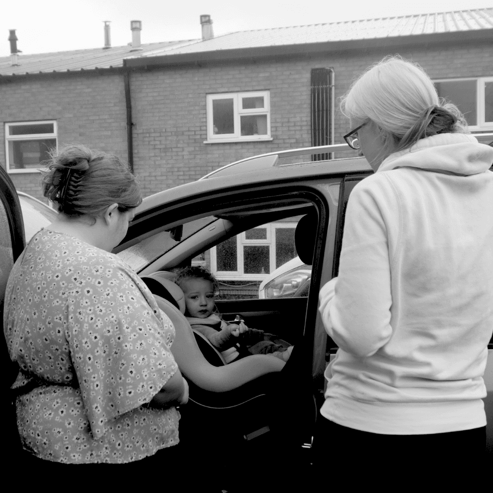 Charlene helping a family check the fit of their child car seat